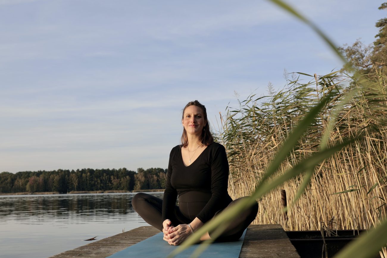 Giulia Leischik in einer Yoga-Pose am See